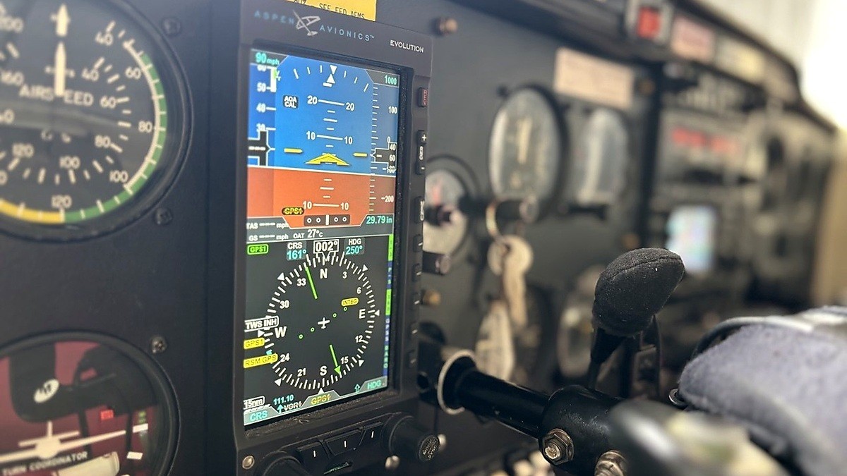 Panel de instrumentos de aeronave liviana con pantalla Aspen Avionics mostrando actitud, rumbo, altitud y navegación
